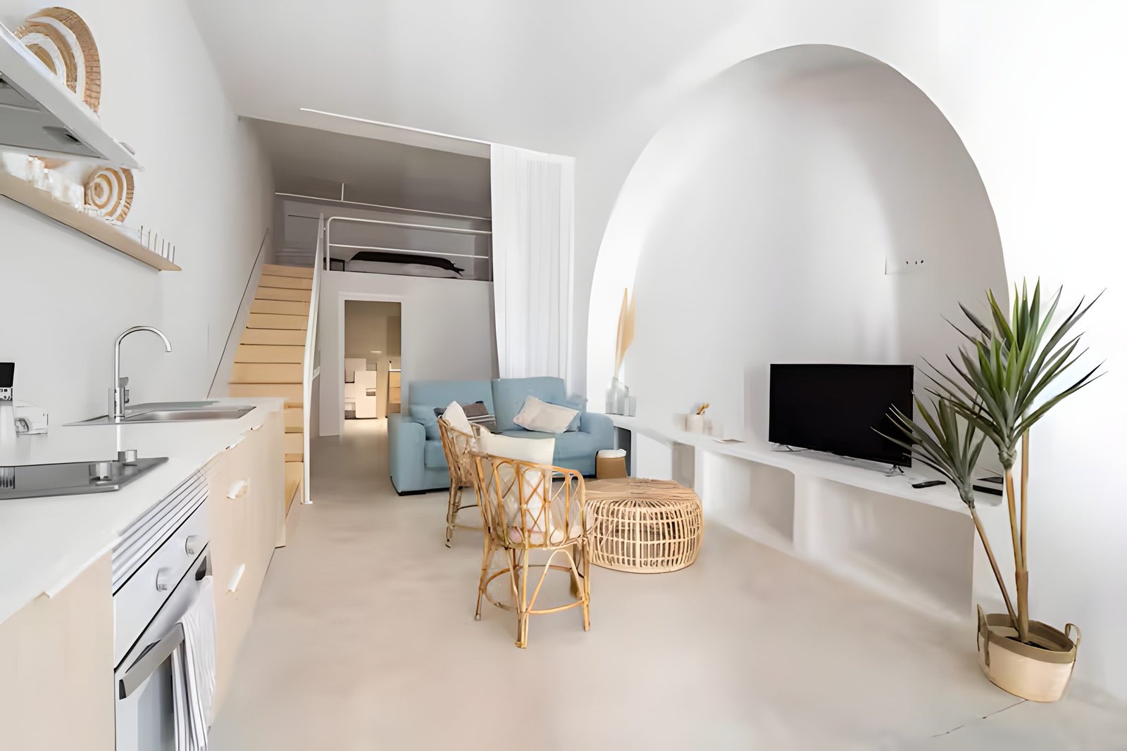 Vista general del loft con cocina, salón y escalera al altillo